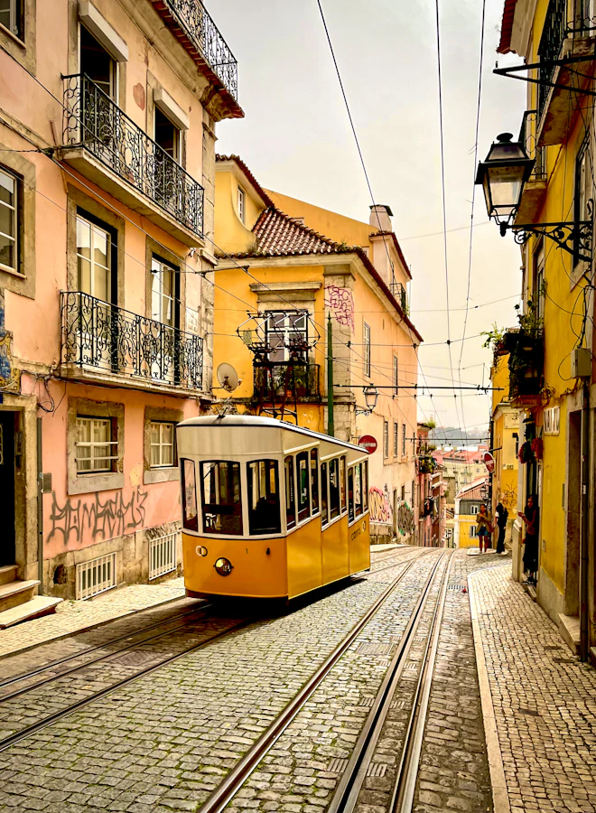 A yellow tram climbing a Lisbon street