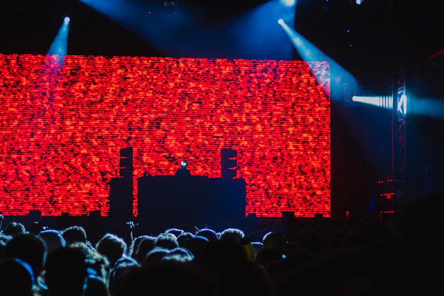 A crowd raising their hands in front of a red stage